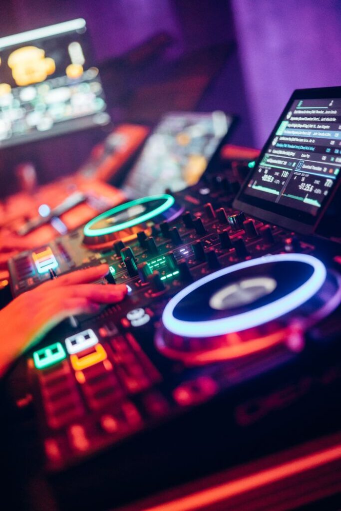 DJ equipment with illuminated turntables and neon lights creating a vibrant nightclub atmosphere.